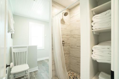 y baño con ducha a ras de suelo y toallas blancas. en The Duffy House, en Seaside
