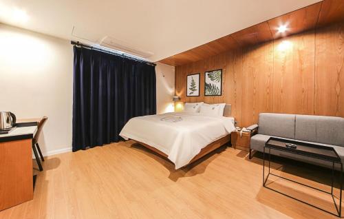 una camera d'albergo con letto e divano di Gray 191 Hotel a Busan