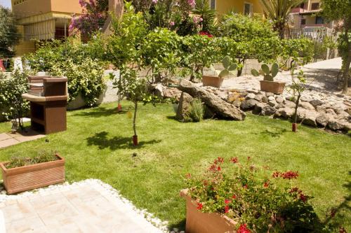 a garden with trees and flowers in a yard at Real B&B Primo Sole in Castelsardo
