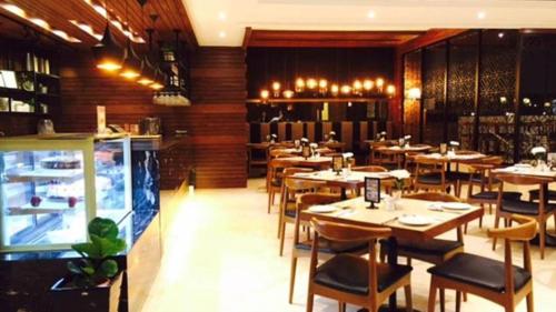 a restaurant with wooden walls and tables and chairs at Sabah Oriental Hotel in Kota Kinabalu