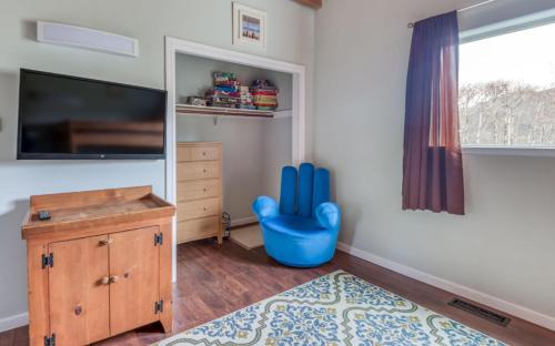 a small room with a blue chair and a television at The Strand at Twin Rocks in Rockaway Beach