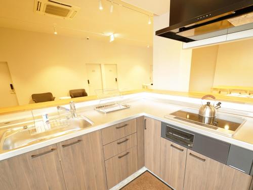 una cocina con 2 lavabos y un espejo grande en OiseSun CAFE & HOTEL en Hyuga