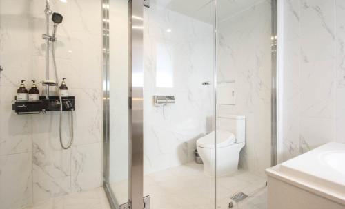 bagno bianco con doccia e servizi igienici di Gray 191 Hotel a Busan
