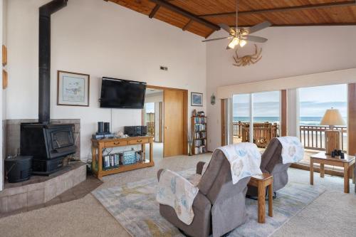 a living room with a fireplace and a television at Twin Coho in Rockaway Beach