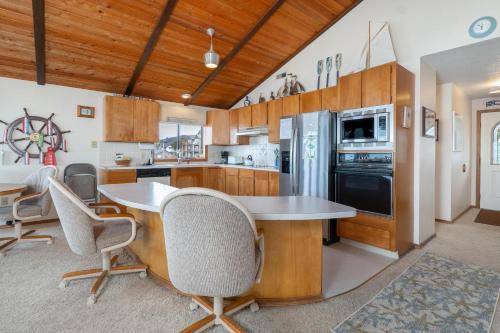 a kitchen with wooden cabinets and a table and chairs at Twin Coho in Rockaway Beach