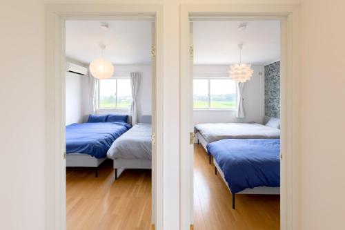 a room with three beds and two windows at ANGO KUJUKURI I in Yokoshibahikari