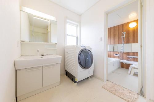 a bathroom with a sink and a washing machine in it at ANGO KUJUKURI I in Yokoshibahikari