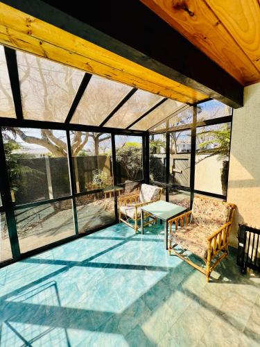 a screened in porch with a table and chairs at Wylie Court Motor Lodge in Rotorua