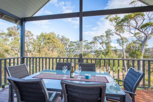 eine Terrasse mit Tisch und Stühlen auf einem Deck in der Unterkunft Chirriger on Inlet I Private Properties in Walpole