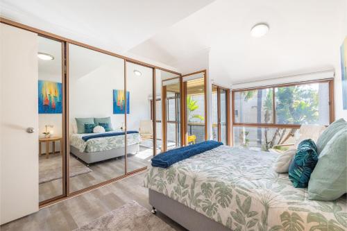 a bedroom with a bed and some glass walls at The Moorings 18 4 Cromarty Rd Waterfront, Pool, Wifi & AirCon in Soldiers Point