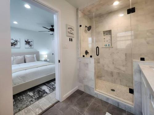 a bathroom with a shower and a bed in a room at NEW! H-Town Getaway Near Medical Center! in Houston