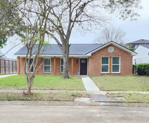a brick house with a tree in front of it at NEW! H-Town Getaway Near Medical Center! in Houston