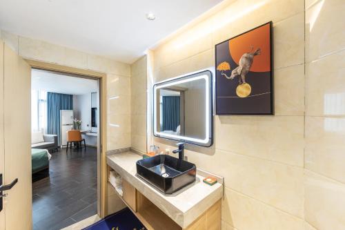 een badkamer met een wastafel en een spiegel bij Jiahua Hotel - Wanzai Ancient City in Wanzai