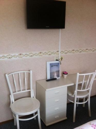 a room with two chairs and a desk with a laptop at Hotel Brinkzicht in De Koog
