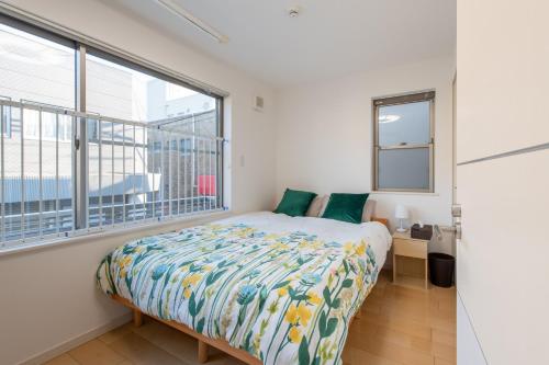 a bedroom with a bed and a large window at 新宿6丁目戸建 in Tokyo