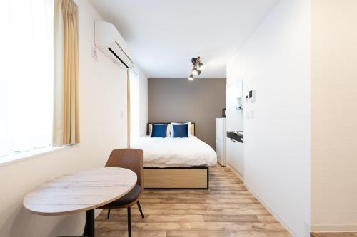 a small bedroom with a bed and a table at Verde Ikebukuro in Tokyo