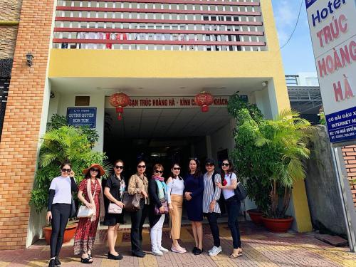 a group of people standing in front of a building at Trúc Hoàng Hà Hotel in Kon Tum