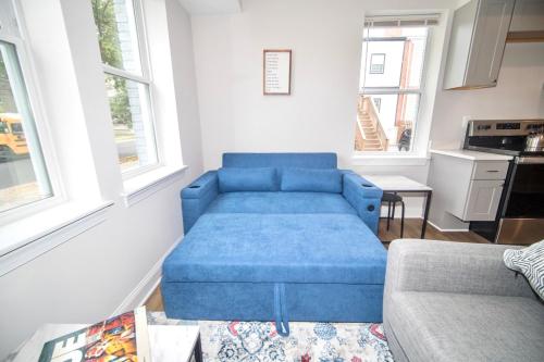 a blue couch in a living room with windows at The Elise :Home Away From Home in Washington, D.C.