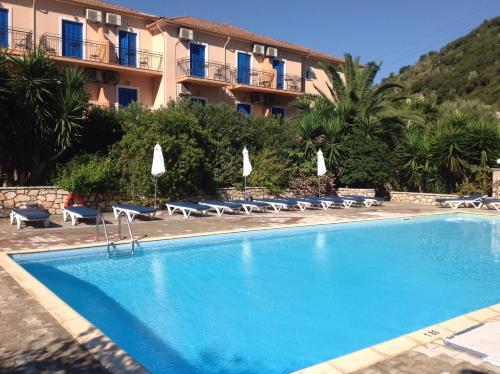 a swimming pool in front of a hotel at Hotel Nostos in Frikes