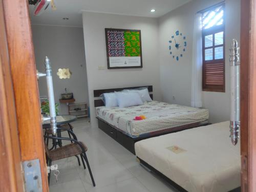 a bedroom with two beds and a table in it at Homestay Erna Tanjong Tinggi in Pasarbaru