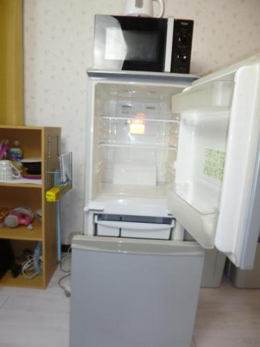 een koelkast met een open deur en een magnetron bij Stay Like Living IJIRI 103 in Shiobaru