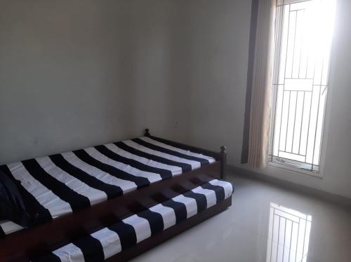 ein Schlafzimmer mit einem Bett in einem Zimmer mit einem Fenster in der Unterkunft Homestay Omah Venus in Jenggrik