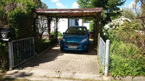 a small blue car parked under a gate at Haus Katharina in Loissin