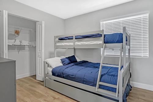 1 dormitorio con 2 literas y escalera en Sistrunk Shades Villas #3 - Brand New Townhomes Downtown Fort Lauderdale, en Fort Lauderdale