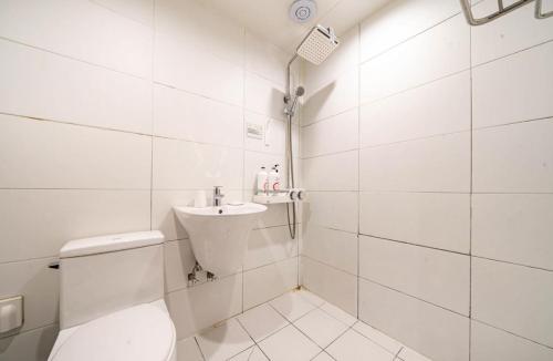 La salle de bains blanche est pourvue de toilettes et d'un lavabo. dans l'établissement Hotel Chicago, à Jinju
