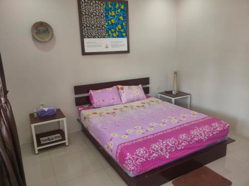 um quarto com uma cama rosa e 2 almofadas em Homestay Melty Aprianti Tanjong Tinggi em Pasarbaru