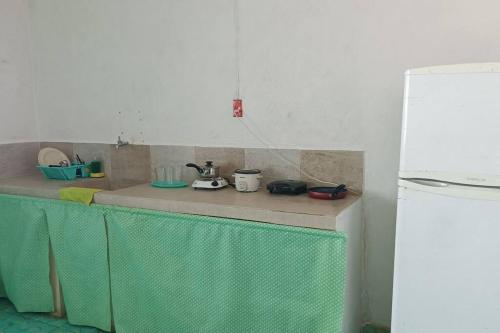 eine Küchentheke mit Spüle und Kühlschrank in der Unterkunft Apto Yori: amplio y equipado. in Mérida