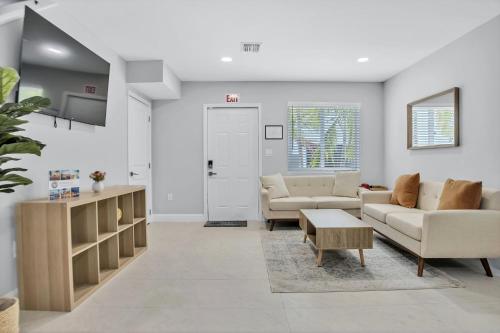 a living room with two couches and a table at Sistrunk Shades Villa #4 - Townhome Downtown Fort Lauderdale Near Cruise Port & FLL in Fort Lauderdale