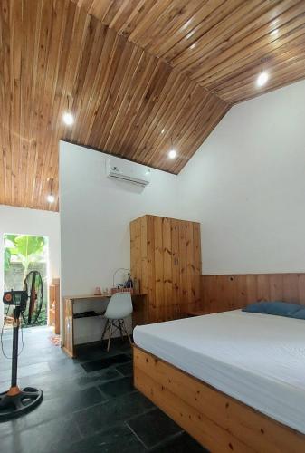 a bedroom with a large bed and a desk at Vom Vom Garden House in Danang