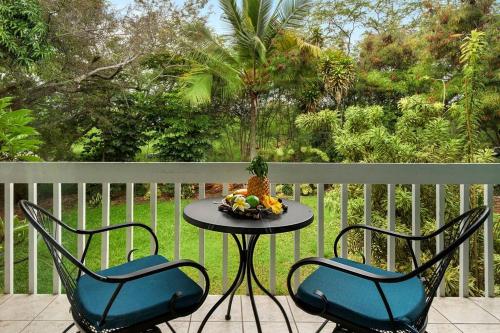 two chairs and a table with a bowl of fruit on a porch at New A/C Central Kona Surf House 4bd/4bth Sleeps8 in Kailua-Kona