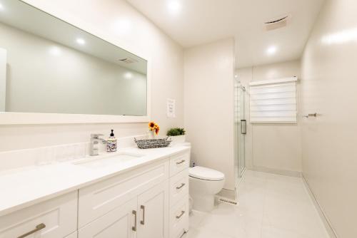 Baño blanco con lavabo y aseo en Toronto Luxurious Designer Villa 5 Bedrooms Detached in Posh Area Central Location Over 10000 Sqft Huge Villa, en Mississauga