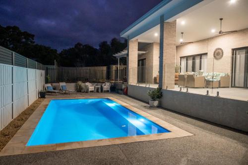 a swimming pool in front of a house at night at Treveth in Angaston