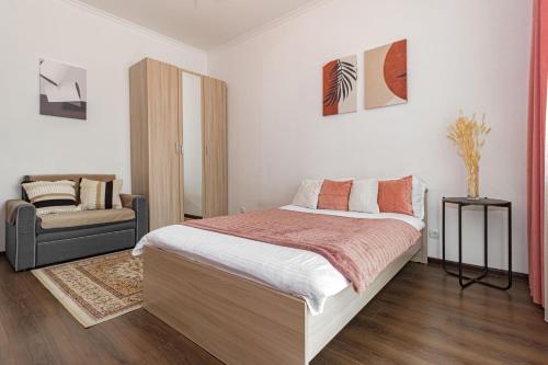 a bedroom with a large bed and a chair at Уютная Квартира Expo Boulevar in Astana