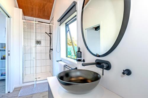 a bathroom with a bowl sink and a mirror at Black Label Retreats in Gisborne