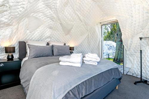 sypialnia z łóżkiem z ręcznikami w obiekcie Black Label Retreats w mieście Gisborne