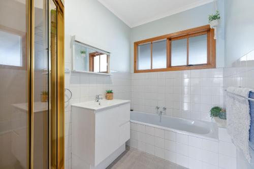a white bathroom with a sink and a tub at Key Lime Retreat in Cape Woolamai