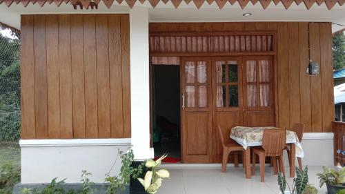 Homestay Suryati Tanjong Tinggi في Pasarbaru: طاولة وكراسي أمام المنزل