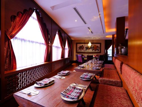 a dining room with long tables in a restaurant at Holiday Inn Kuwait by IHG in Kuwait
