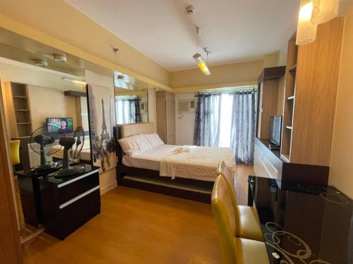 Habitación pequeña con cama y TV. en 8 Adriatico, en Manila