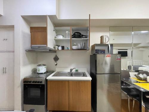 a small kitchen with a sink and a refrigerator at 8 Adriatico Staycation in Manila