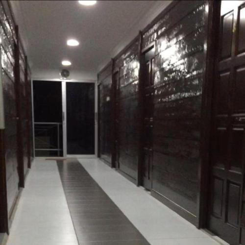 a hallway with black doors and a white floor at Bonsai Homestay Kluang - B17 in Kluang