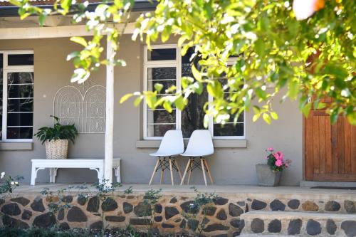 two white stools in front of a house with two windows at Gowan Valley Guest Farm in Balgowan