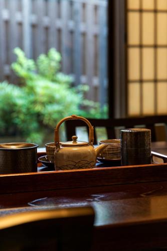 a purse sitting on top of a table with cups at Yufuin Yufusaryo in Yufuin