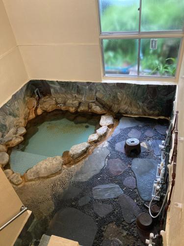 a large pool of water in a room with a window at Hotel shirahama in Shirahama