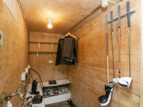 uma casa de banho com paredes de madeira e um chuveiro com lavatório. em Heatherbank em Garelochhead