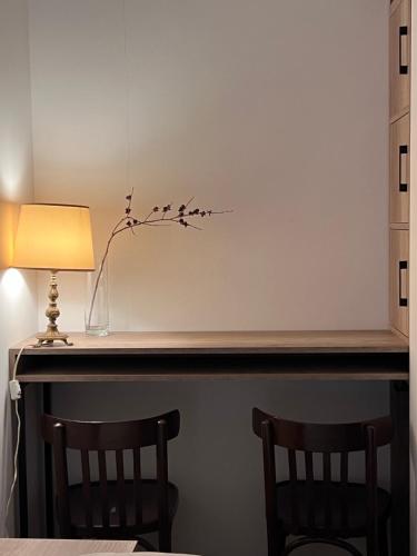 a table with two chairs and a vase and a lamp at Green Agarak Guest House near Dendropark, Stepanavan in Gyulagarak